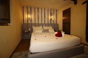 una camera da letto con un grande letto bianco con rose sopra di Love Story - Piscina & Sauna - Lareira a Arcos de Valdevez Altre 34 foto