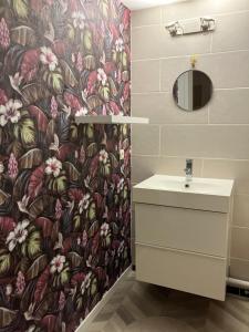 a bathroom with a flower patterned shower curtain and a sink at Emplacement top avec parking au Stade de France 2mn de Paris 20 de Roissy CDG et 30 de La Défense in Saint-Denis