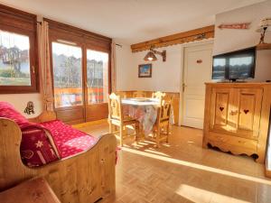 a living room with a table and a tv at Appartement Flumet, 3 pièces, 6 personnes - FR-1-505-13 in Flumet