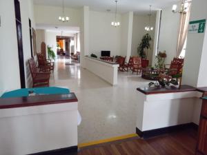 un vestíbulo vacío de un hospital con mesas y sillas en Hotel Silvia by Destino Pacifico en Silvia