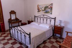 a bedroom with a bed and two tables and a mirror at Masseria Caliani in Borgagne