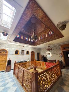 a synagogue with a wooden staircase and stained glass ceilings at Riad Royal in Meknès