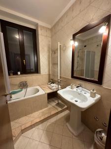 bagno con lavandino, vasca e specchio di Bed & Breakfast Federico II a Barletta