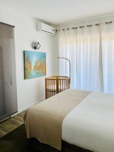 sypialnia z łóżkiem i oknem w obiekcie Apartamento Gandarinha junto ao Mar w mieście Cascais