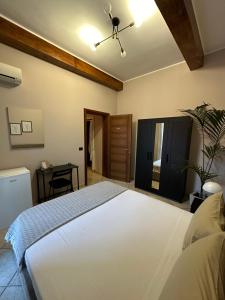 a bedroom with a large white bed and a desk at Bed & Breakfast Federico II in Barletta