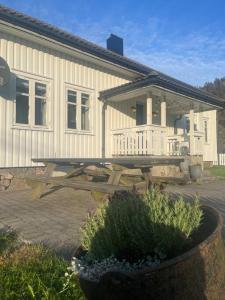 una mesa de picnic de madera frente a una casa en sjarmerende gardshus, en Hægebostad