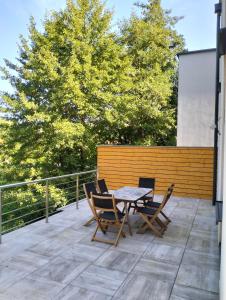 a patio with a table and chairs on a deck at Au fil de l'eau in Lapoutroie