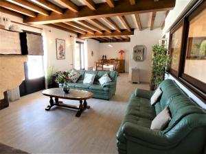 a living room with a green couch and a table at Maison dailhen in Préchacq