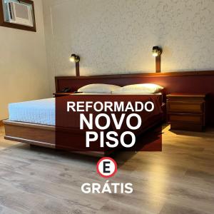 uma cama com uma placa que diz "pizza reinomo novo" em Blumenau Tower by Castelo Itaipava em Blumenau