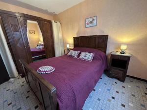 um quarto com uma cama com uma colcha roxa em Lamoune em Duhort-Bachen