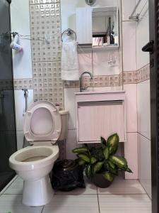 La salle de bains est pourvue de toilettes et d'une plante. dans l'établissement Reflejos de Luna Llena, à Puerto Iguazú