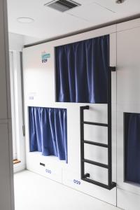 um quarto com cortinas azuis e uma escada em Hostel Villa Miguela em Santander