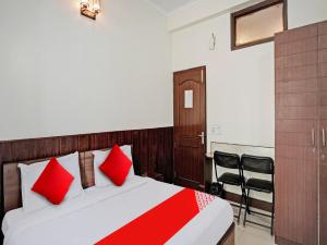 ein Schlafzimmer mit einem Bett mit roten Kissen in der Unterkunft Hotel Grand Stay in Ghaziabad