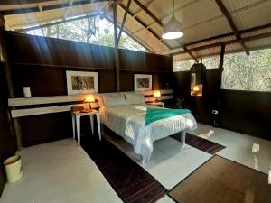 1 dormitorio con 1 cama y 2 mesas con lámparas en The Tshilli Farm & Lodge, en Maun