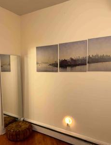 Zimmer mit vier Gemälden an einer Wand mit Licht in der Unterkunft Heavenly 1BR apartment in NYC in New York