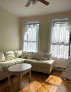 a living room with a white couch and two windows at Heavenly 1BR apartment in NYC in New York