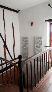 eine Treppe mit zwei Gemälden an der Wand und einem Treppengeländer in der Unterkunft La masqueria in Montgaillard