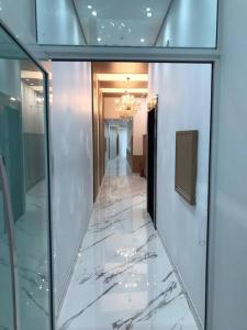 un corridoio di un edificio con pavimenti in marmo e lampadario pendente di Lindo Apto NOVO na Avenida, climatizado e aconchegante a Piratuba