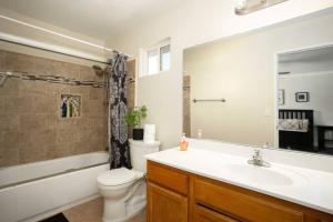 a bathroom with a sink and a toilet and a mirror at Charming 4BR Retreat - Near Old Town Monrovia in Monrovia