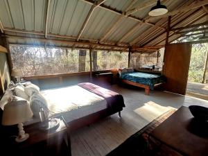 a bedroom with a bed and a couch in a room at The Tshilli Farm & Lodge in Maun