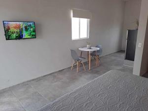 a living room with a table and a tv on the wall at Bungalow Vista Sierra Laguna in San Carlos