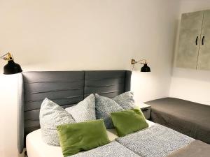 a bedroom with a bed with two green pillows at WEINQUARTIER Weingarten 2 Apartments à 1 SZ Altstadt Terrasse Parken - Tiere erlaubt in Naumburg