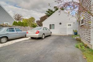 two cars parked in front of a white house at about 1 Mi to Beach Cape Cod Apt in South Yarmouth in Yarmouth