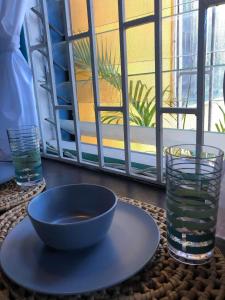 a table with a bowl and a glass of water at BnB SoMom Mobay Lodging in Montego Bay