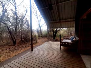 a porch of a house with a bench on it at The Tshilli Farm & Lodge in Maun