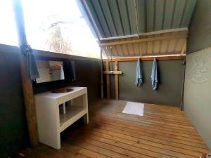 a small bathroom with a sink and a window at The Tshilli Farm & Lodge in Maun