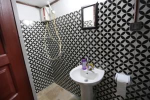 y baño con lavabo y azulejos blancos y negros. en Helvacılar Konağı en Karacasu