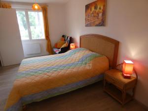 a bedroom with a bed and a window and two lamps at Gite aux fleurs in Hagetmau