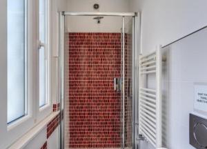 uma casa de banho com uma cabina de duche em vidro e azulejos vermelhos em Appartamento dell'acquedotto romano em Roma