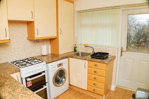 a kitchen with a stove top oven next to a sink at Charming 2-Bedroom in MANCHESTER in Manchester