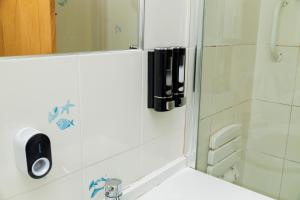 a bathroom with a shower with a mirror and a sink at Charming 2-Bedroom in MANCHESTER in Manchester