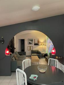 un soggiorno con tavolo e divano di Suite Jacuzzi-Cinéma a Les Clayes-sous-Bois