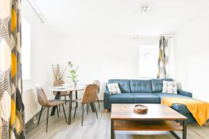 sala de estar con sofá azul y mesa en Evasion Mulhousienne, en Mulhouse