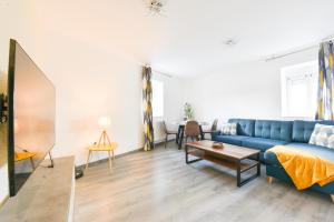 a living room with a blue couch and a table at Evasion Mulhousienne in Mulhouse