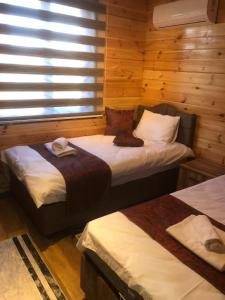 Zimmer mit 2 Betten in einem Blockhaus in der Unterkunft SAPANCA FAMİLY RESORT in Kartepe