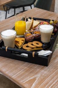 uma bandeja de comida numa mesa com duas bebidas em Suite Dreams Montecatini em Montecatini Terme