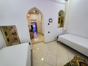a room with two beds and a hallway at Blue City in Chefchaouen