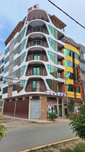 un edificio alto con ventanas coloridas en una calle en HOTEL LA BELLA Y EL LEON en Huánuco