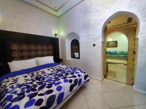 a bedroom with a bed with a blue and white comforter at Blue City in Chefchaouen