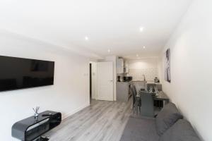 a living room with a dining room table and a kitchen at Glasgow City, Hydro Apartment in Glasgow