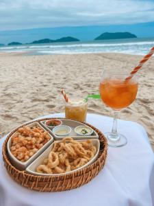 a tray of food and a drink on a table on the beach at Hiu Hotel in Juquei