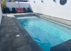 - une piscine d'eau bleue et des chaises dans l'établissement Villa Fleurs de Cannes 4*, à Saint-Louis