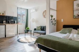 a bedroom with a bed and a couch and a table at Studio Nicehome Massena in Nice