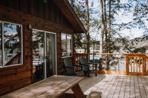 a porch of a cabin with a wooden table and chairs at Page's Resort & Marina in Gabriola