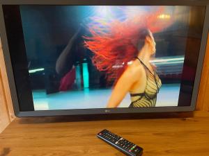 einen Fernseher mit einem Bild einer Frau mit roten Haaren in der Unterkunft Chalet Free Sauna & Spa SuperKing bed in Killaloo