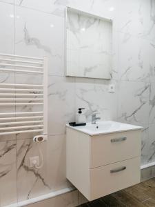 W białej łazience znajduje się umywalka i lustro. w obiekcie NICEHOME MASSENA w Nicei
